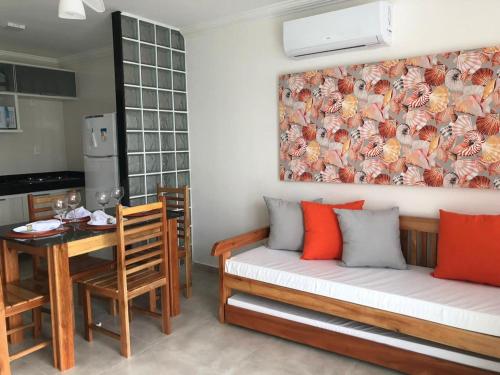 una sala de estar con un sofá y una mesa en Apartamento em Arraial D`Ajuda com Piscina Sauna Academia, en Porto Seguro