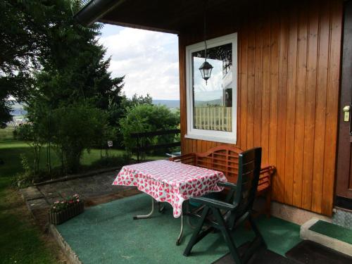 a table and chairs on the porch of a house at Ferienhaus "Eierkuchen" in Lindig