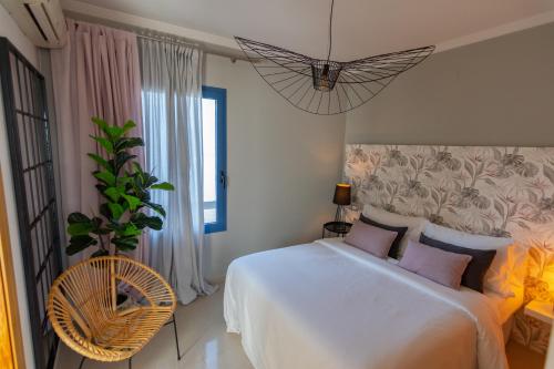 a bedroom with a large white bed and a chair at Villalia Isora in Playa Blanca