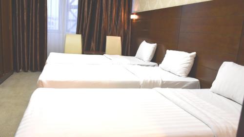 a row of three beds in a hotel room at Mirage Al Salam Hotel in Medina