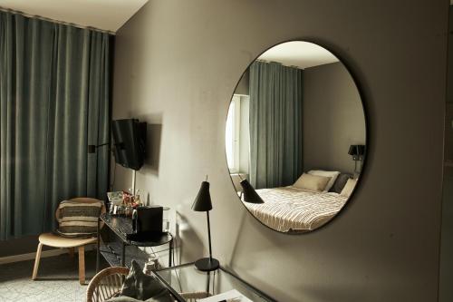 een hotelkamer met een bed en een spiegel bij Hasse på Sjökanten Hotell & Restaurang in Jönköping