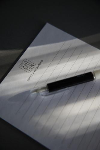 a pen sitting on top of a piece of paper at Hasse på Sjökanten Hotell & Restaurang in Jönköping