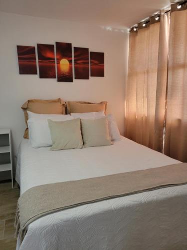 sypialnia z dużym łóżkiem z białą pościelą i poduszkami w obiekcie Sunny Moon Vacation, Private Island in Fajado,PR. w mieście Fajardo