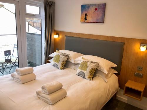 1 dormitorio con 1 cama con toallas en The Glass House - Scarborough en Scarborough