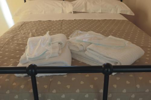 a bed with white towels on top of it at BED&BREAD Piazza 'Nzegna in Carovigno