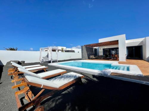 een villa met zwembad en ligstoelen bij Villa Nayra by Villalia in Playa Blanca
