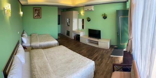 a hotel room with two beds and a television at Emmanuel Farm House in Renai