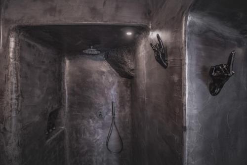 a dark bathroom with a shower and a toilet at Sophia Privilege in Oia