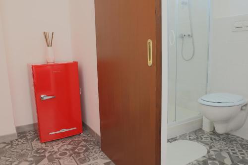 a bathroom with a red refrigerator next to a toilet at BED&BREAD Piazza 'Nzegna in Carovigno