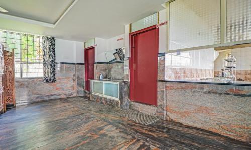 a bathroom with a red door and a sink at Treebo Green Land Kushalnagar in Kushālnagar