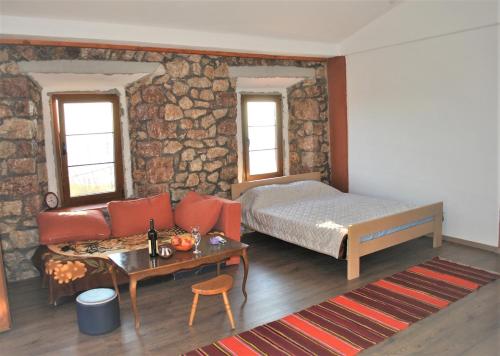 a bedroom with a bed and a couch and a table at Etno house Velje Selo in Bar