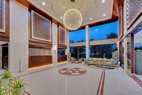 a lobby of a building with windows and a chandelier at The Fern Residency Hubballi in Hubli
