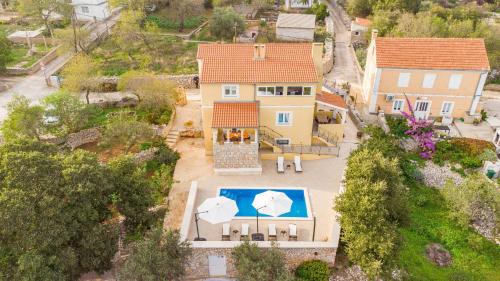 an aerial view of a house with a swimming pool and umbrellas at Villa Sali ZadarVillas in Sali
