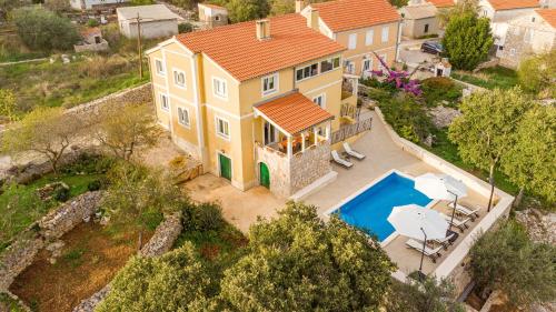 an aerial view of a yellow house with a swimming pool at Villa Sali ZadarVillas in Sali
