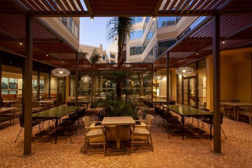 a restaurant with tables and chairs in a building at TURIM Presidente Hotel in Portimão