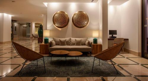 a living room with a couch and two chairs at TURIM Presidente Hotel in Portimão