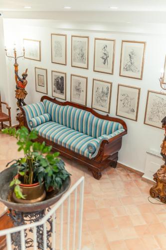 a living room with a blue couch and pictures on the wall at Hotel Villa Paradiso in Taormina