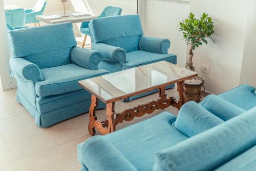 a living room with blue chairs and a table at Hotel Villa Paradiso in Taormina