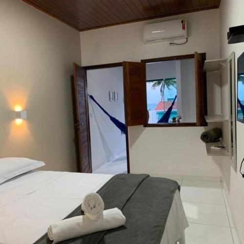 a bedroom with a bed with a towel on it at Flat Galemares in Maragogi