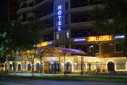 a building with a sign that reads the alchemist at ATB Grand Hotel in Atyraū