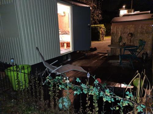 einen Hinterhof in der Nacht mit einem Tisch und einem Fenster in der Unterkunft La roulotte in Travers