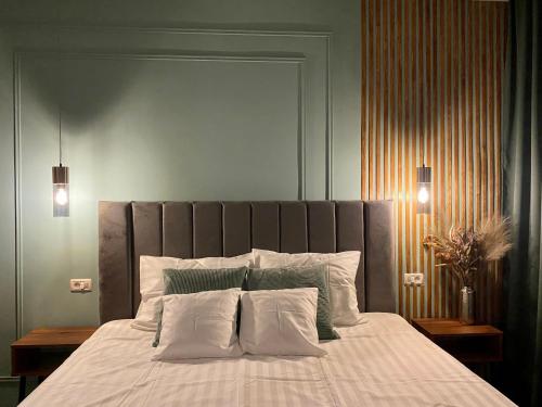 a bedroom with a large bed with white sheets and pillows at CoolKush Boutique in Constanţa