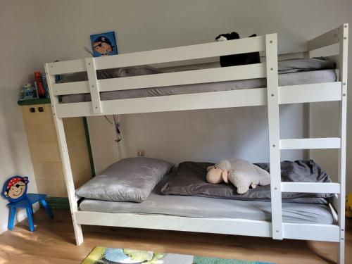a white bunk bed with a stuffed animal laying on it at FAMILY APARTMENT LINZ Wohnen mit Garten am Fusse des Pöstlingbergs TOP LAGE Villenviertel in Linz