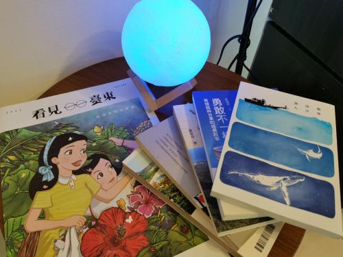 a table topped with books and a blue balloon at 台東市民宿賞星月沐文創館Enjoy Star丨網紅民宿丨親子友善丨寵物友善丨療癒民宿丨可包棟自動麻將機卡拉OK機丨雅致庭院丨近機場娜路彎酒店 l 可自助入住 in Taitung City