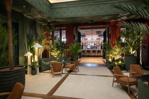 a lobby with plants and tables and chairs at Only YOU Hotel Málaga in Málaga