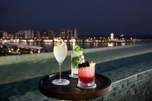 two cocktails sitting on a table on a balcony at Only YOU Hotel Málaga in Málaga