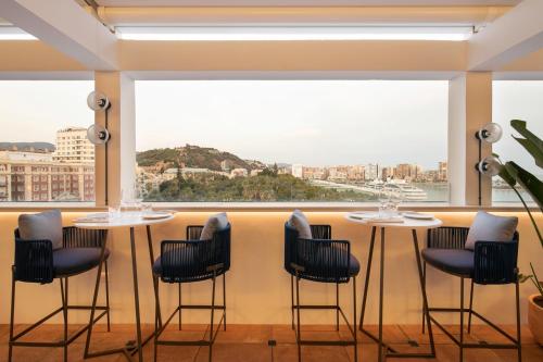 a room with two tables and chairs and a large window at Only YOU Hotel Málaga in Málaga