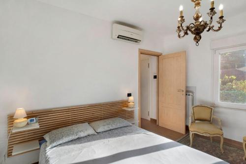a bedroom with a bed and a chandelier and a chair at Santa Lucia in Imperia