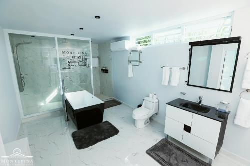 a bathroom with a sink and a shower and a toilet at Montefina Villa Boutique in San Sebastian