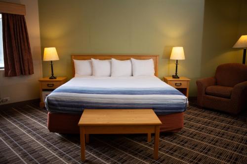 a hotel room with a bed and a chair at AmericInn by Wyndham Pampa Event Center in Pampa
