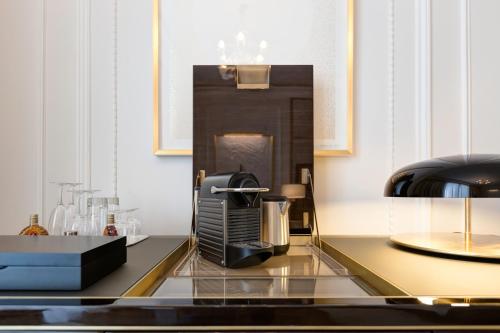 a kitchen with a coffee table and a coffee maker at Hôtel de Paris Monte-Carlo in Monte Carlo