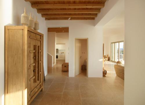 a living room with a large wooden cabinet in a room at Absolute Paradise Villa Tourlos in Mikonos