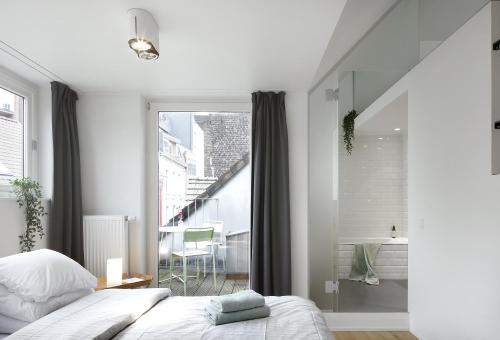 a bedroom with a bed and a large window at Loftsuite in Ghent