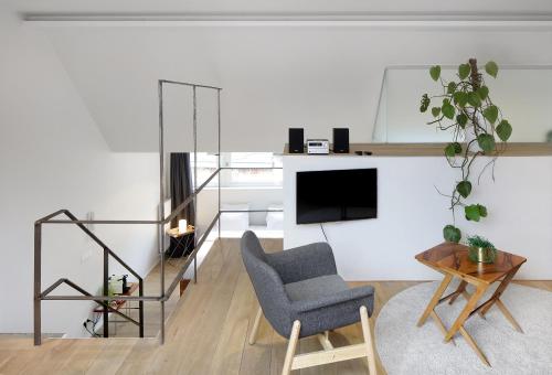 a living room with a chair and a tv at Loftsuite in Ghent