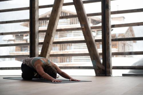 a man is doing a yoga pose on the floor at Naturresort PURADIES in Leogang