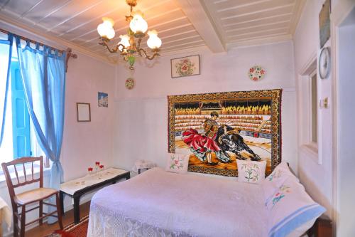 a bedroom with a bed and a painting on the wall at Skopelos house in Castle in Panormos Skopelos