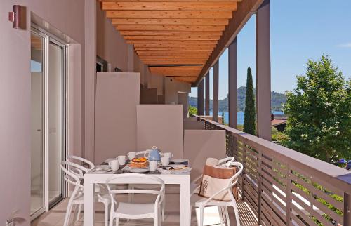 a white table and chairs on a balcony at Lamasu RioVerde - Lago di Garda in San Felice del Benaco
