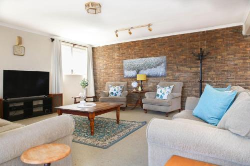 a living room with two couches and a tv at 5 bedroom Traditional Fisherman's old Gem w panoramic views, Bloubergstrand, Cape Town in Bloubergstrand