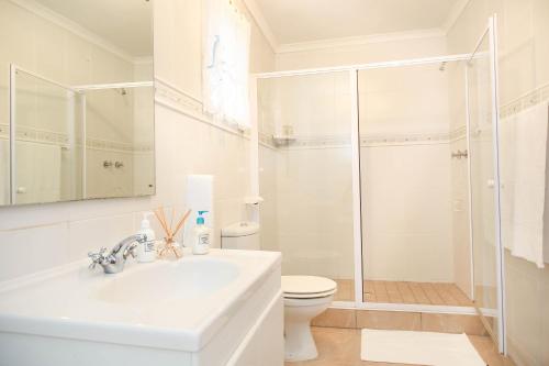 a white bathroom with a sink and a shower at 5 bedroom Traditional Fisherman's old Gem w panoramic views, Bloubergstrand, Cape Town in Bloubergstrand