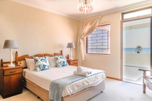 a bedroom with a large bed and a window at 5 bedroom Traditional Fisherman's old Gem w panoramic views, Bloubergstrand, Cape Town in Bloubergstrand