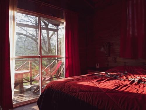 a bedroom with a bed and a large window at Cabaña Ilusión - Complejo Marea in Tigre