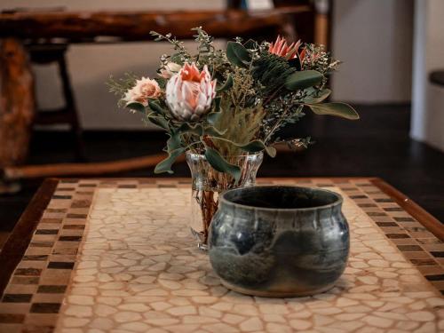 a vase with flowers in it sitting on a table at Linvale Country Lodge in Hazyview