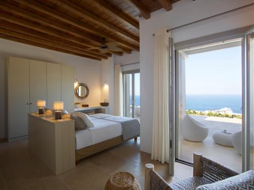 a bedroom with a bed and a view of the ocean at Absolute Paradise Villa Tourlos in Mikonos