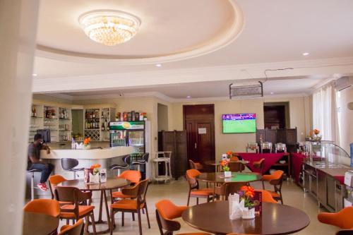 a restaurant with tables and chairs in a room at Sonia Hotel in Accra
