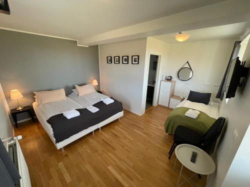 a bedroom with two beds and a television in it at Hótel Lækur in Hella