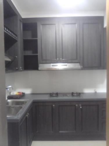 a kitchen with dark wood cabinets and a sink at CENTRAL OF MELAKA- 3 room type in Melaka